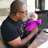 A man carries a baby in his hand